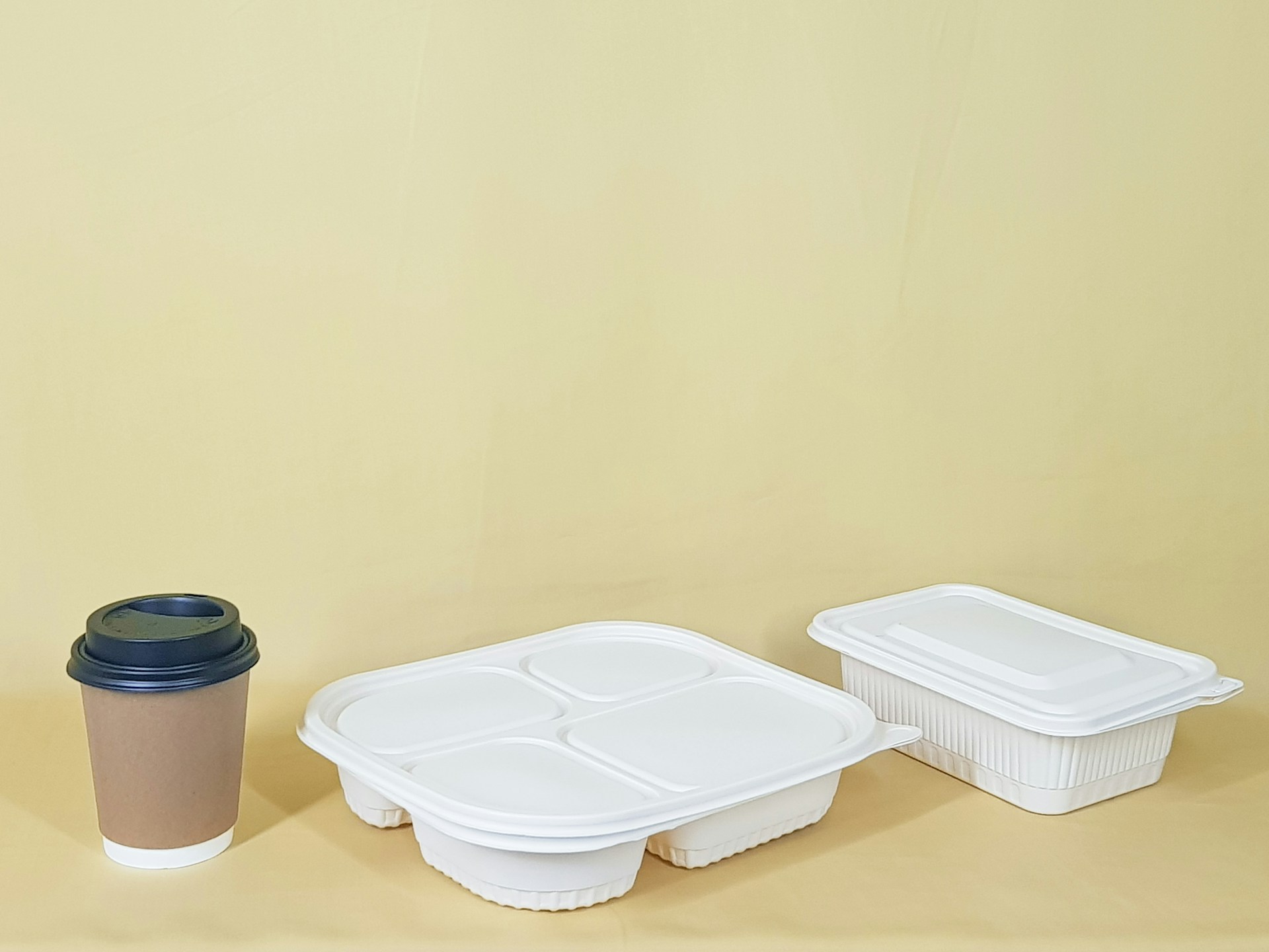 Une tasse à côté de deux récipients alimentaires | Source : Unsplash