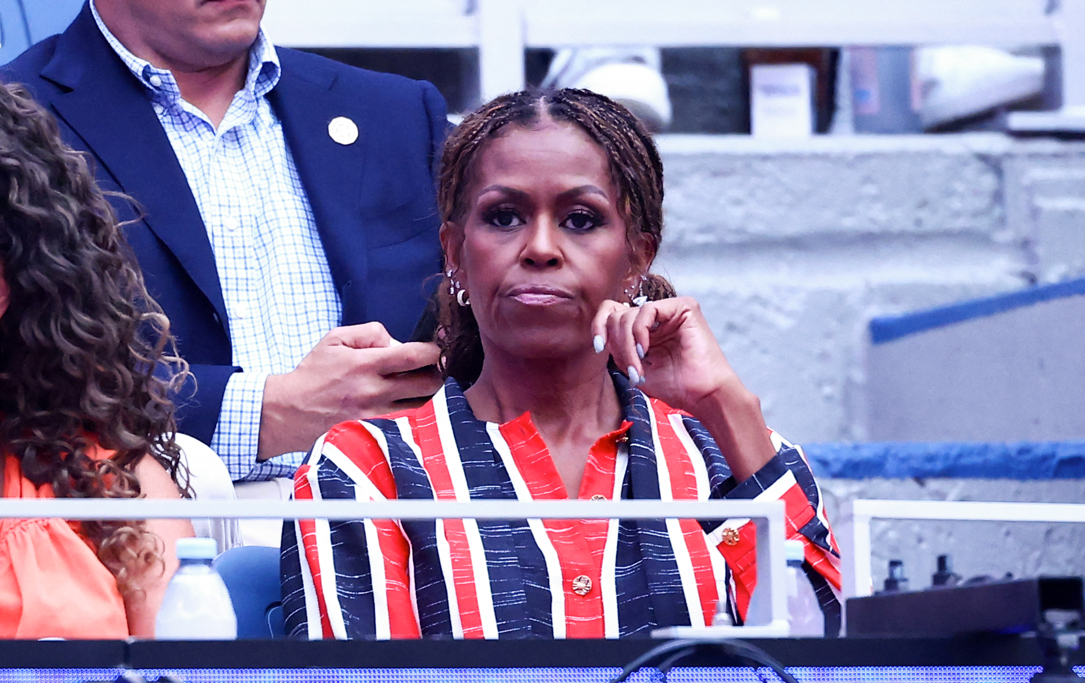 La parure d'oreilles dorées n'était pas le seul détail que Michelle a repris tout au long de sa tenue. Elle portait aussi plusieurs bagues, tandis que la robe elle-même était agrémentée de boutons dorés, ce qui permettait d'harmoniser ces piercings plutôt ludiques avec une tenue Chanel par ailleurs très soignée. | Source : Getty Images
