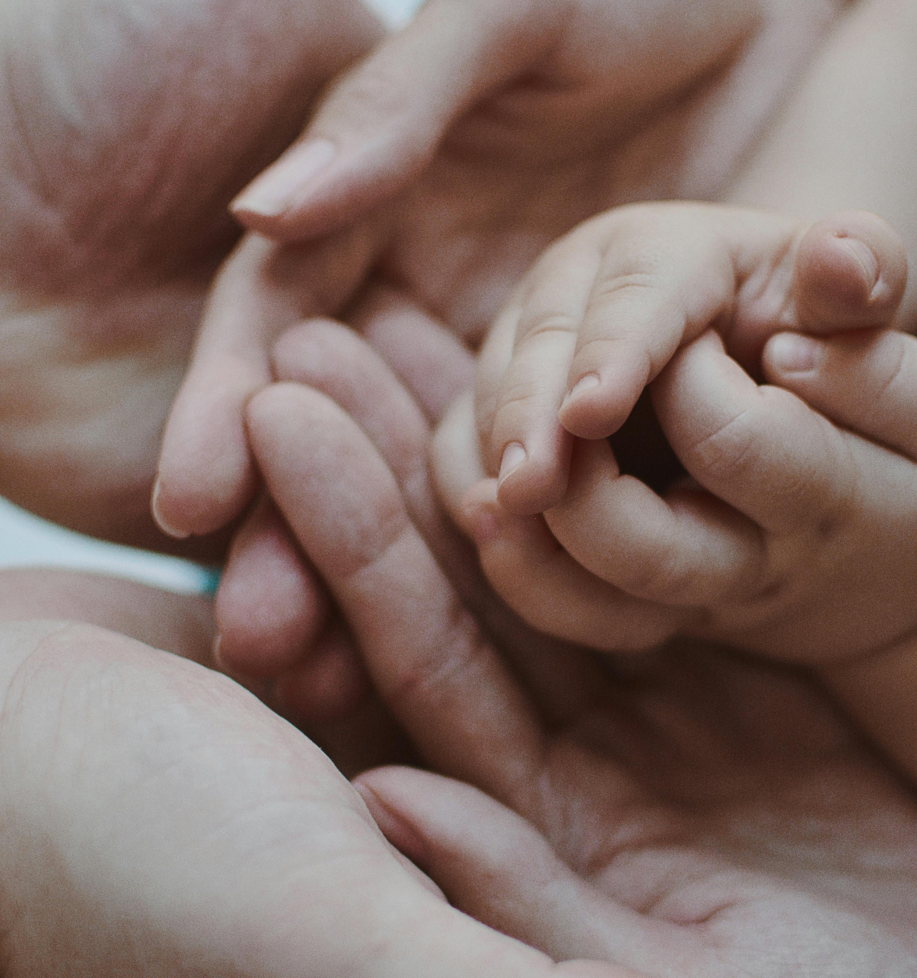 De nouveaux parents tenant les mains de leur bébé | Source : Pexels