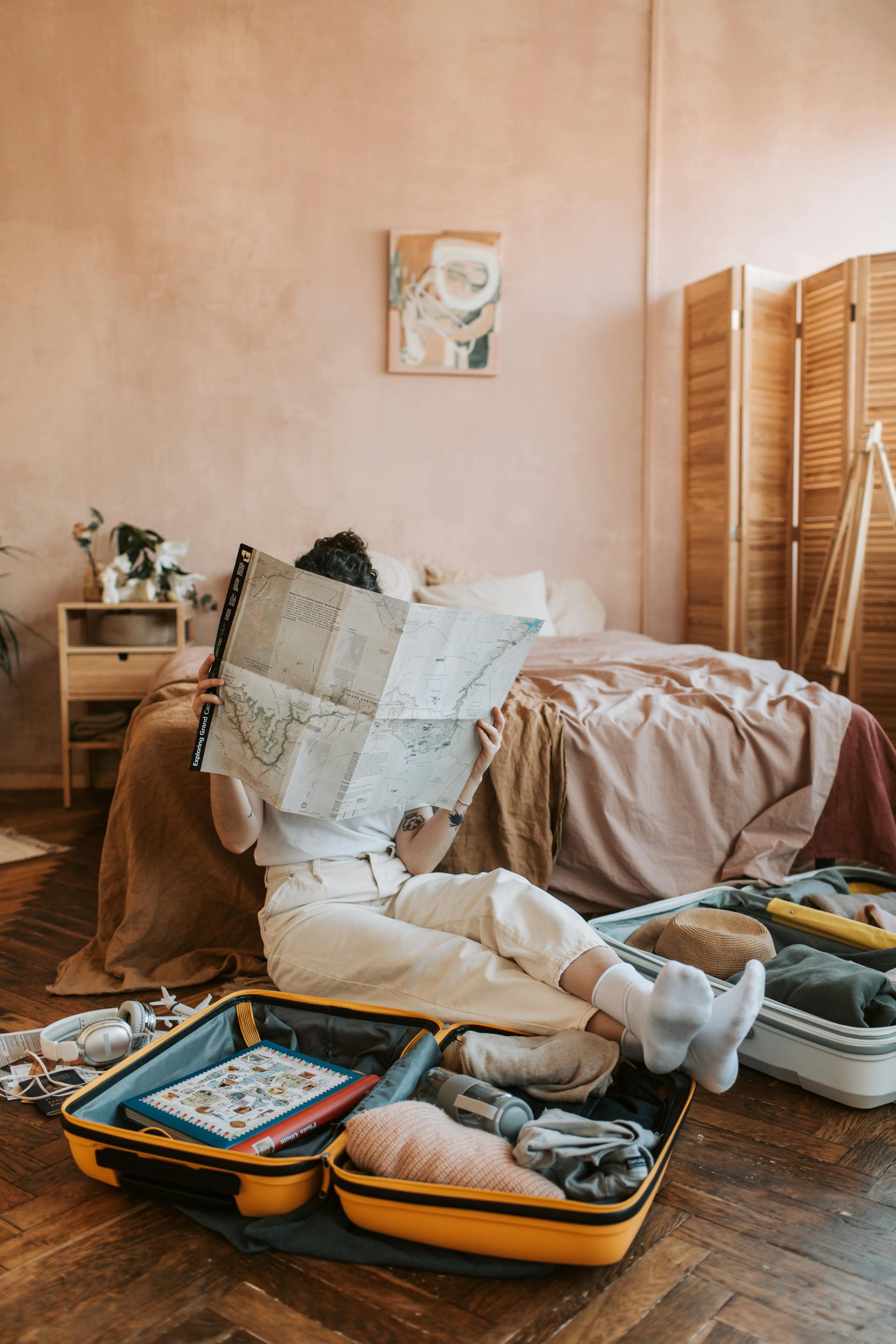 Une femme regarde une carte avec des bagages autour d'elle | Source : Pexels