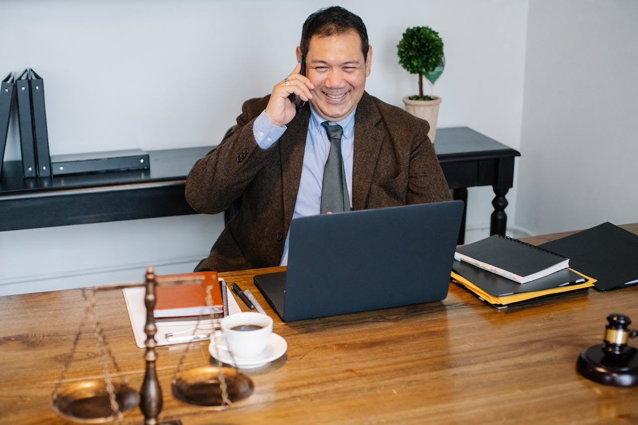 Un avocat en train de parler au téléphone dans son bureau | Source : Pexels