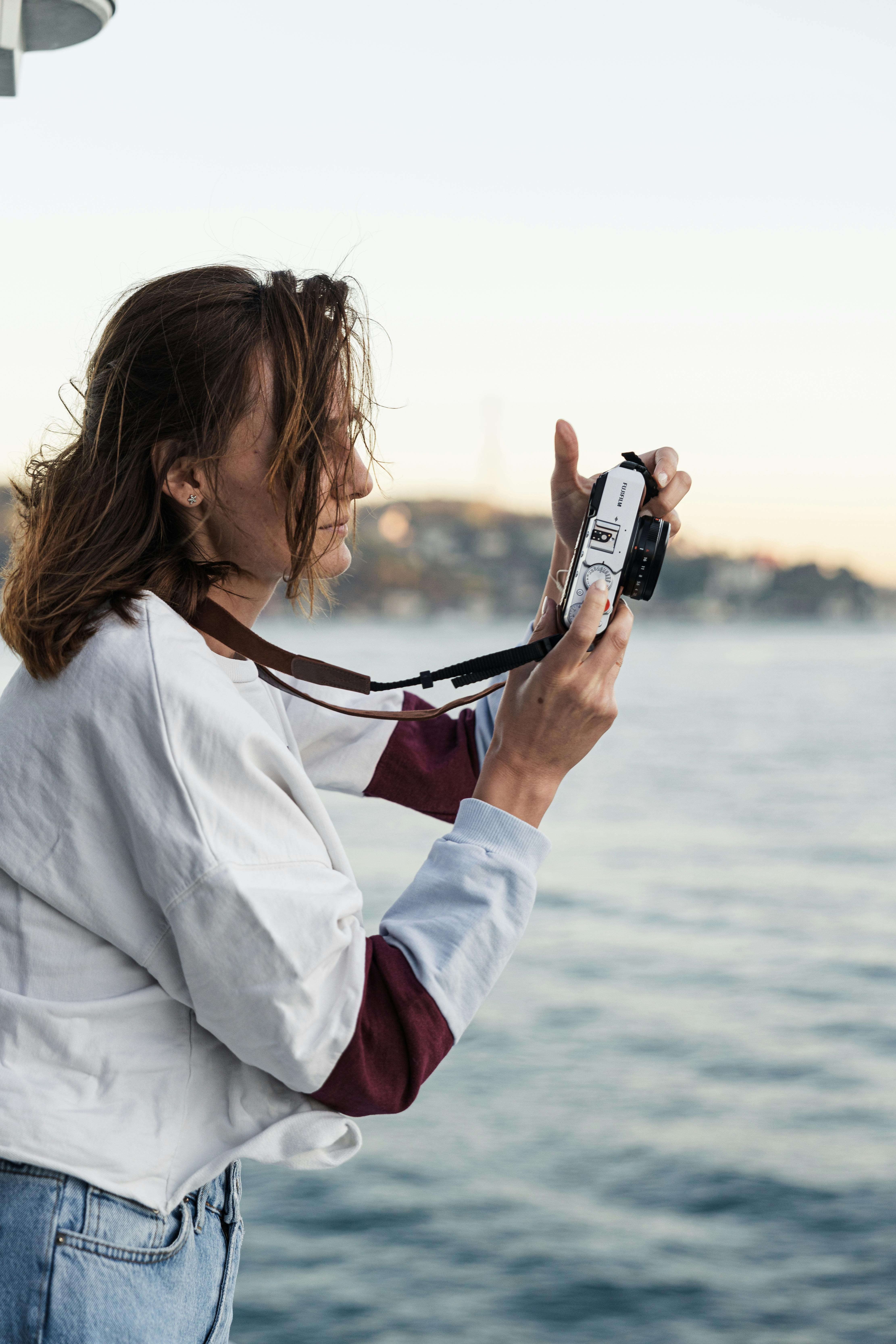 Une femme prend une photo sur la plage | Source : Pexels