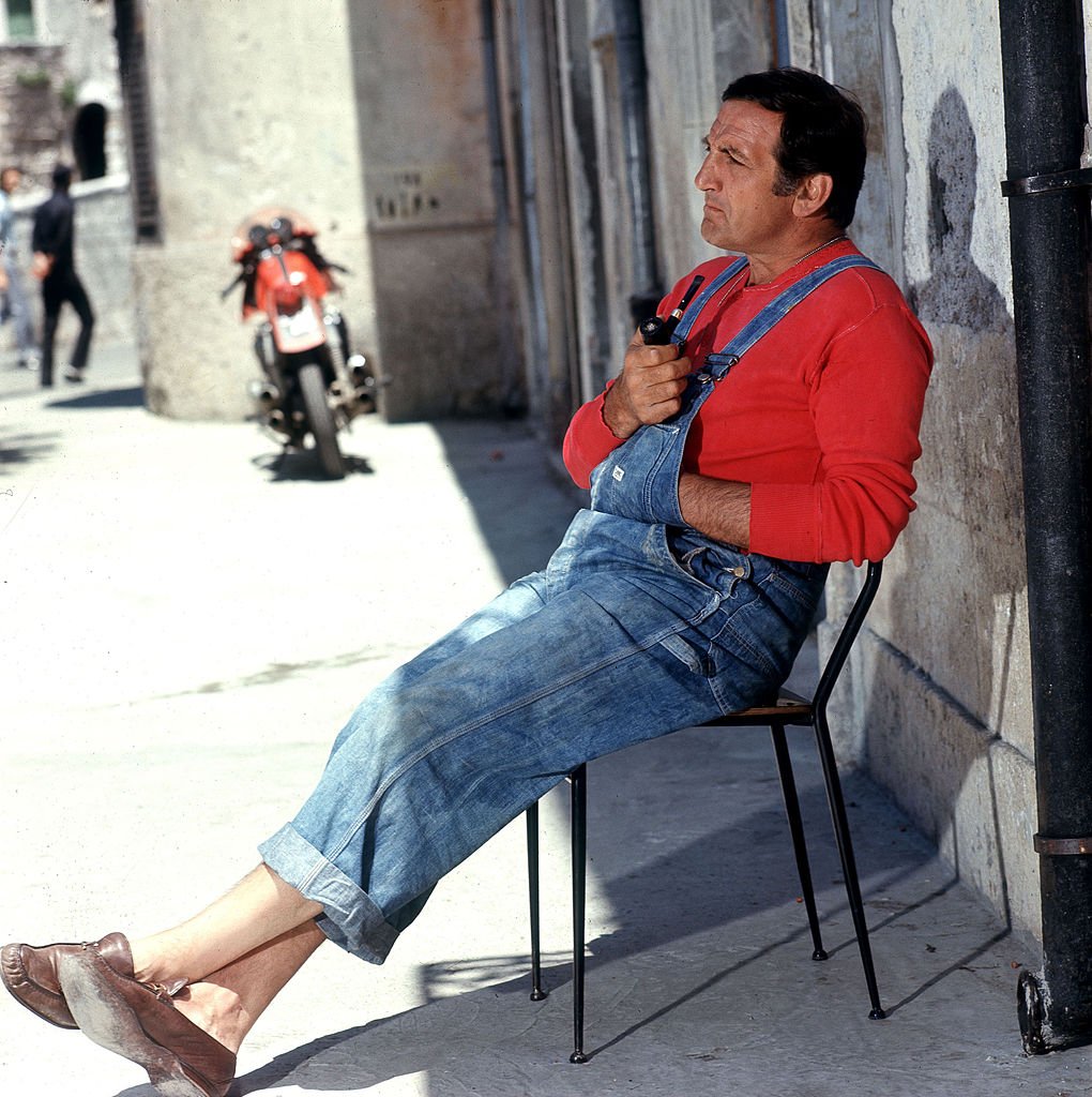 L'acteur italien Lino Ventura fait une pause sur le plateau en fumant une pipe. Années 1960. | Photo : Getty Images