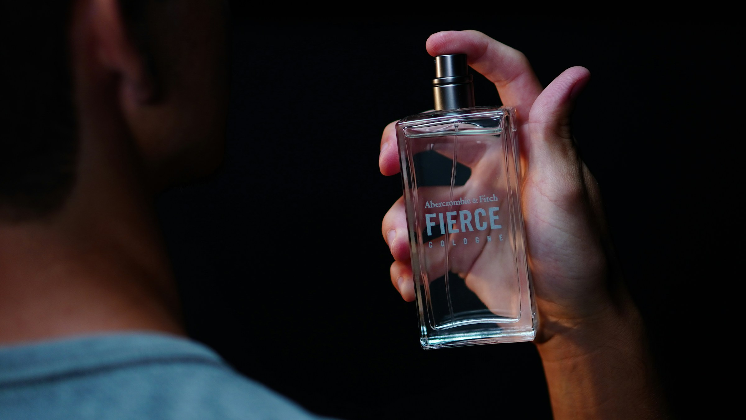 Gros plan sur un homme tenant un flacon de parfum | Source : Unsplash
