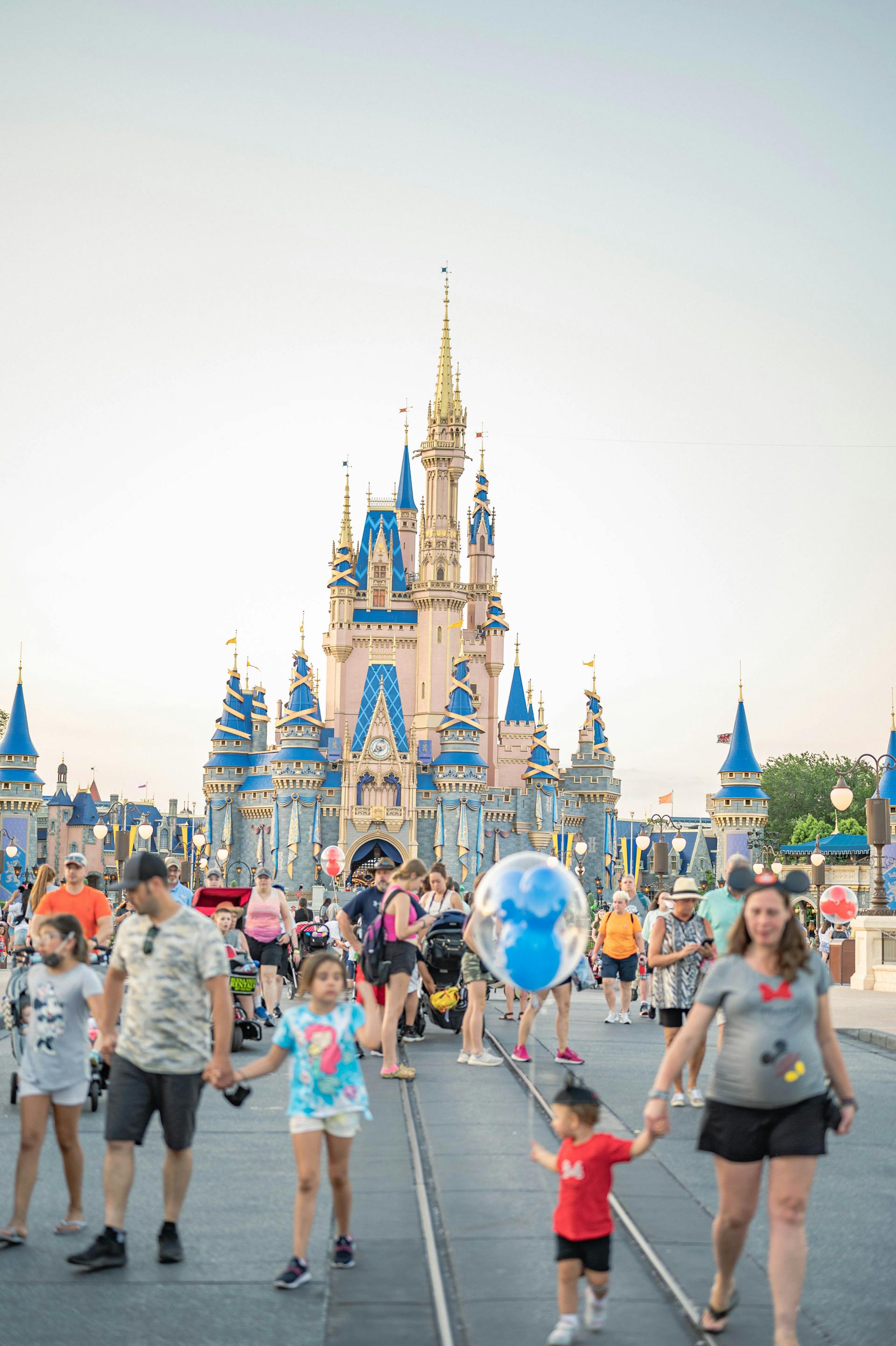 Des gens marchent près d'un château de Disney | Source : Pexels