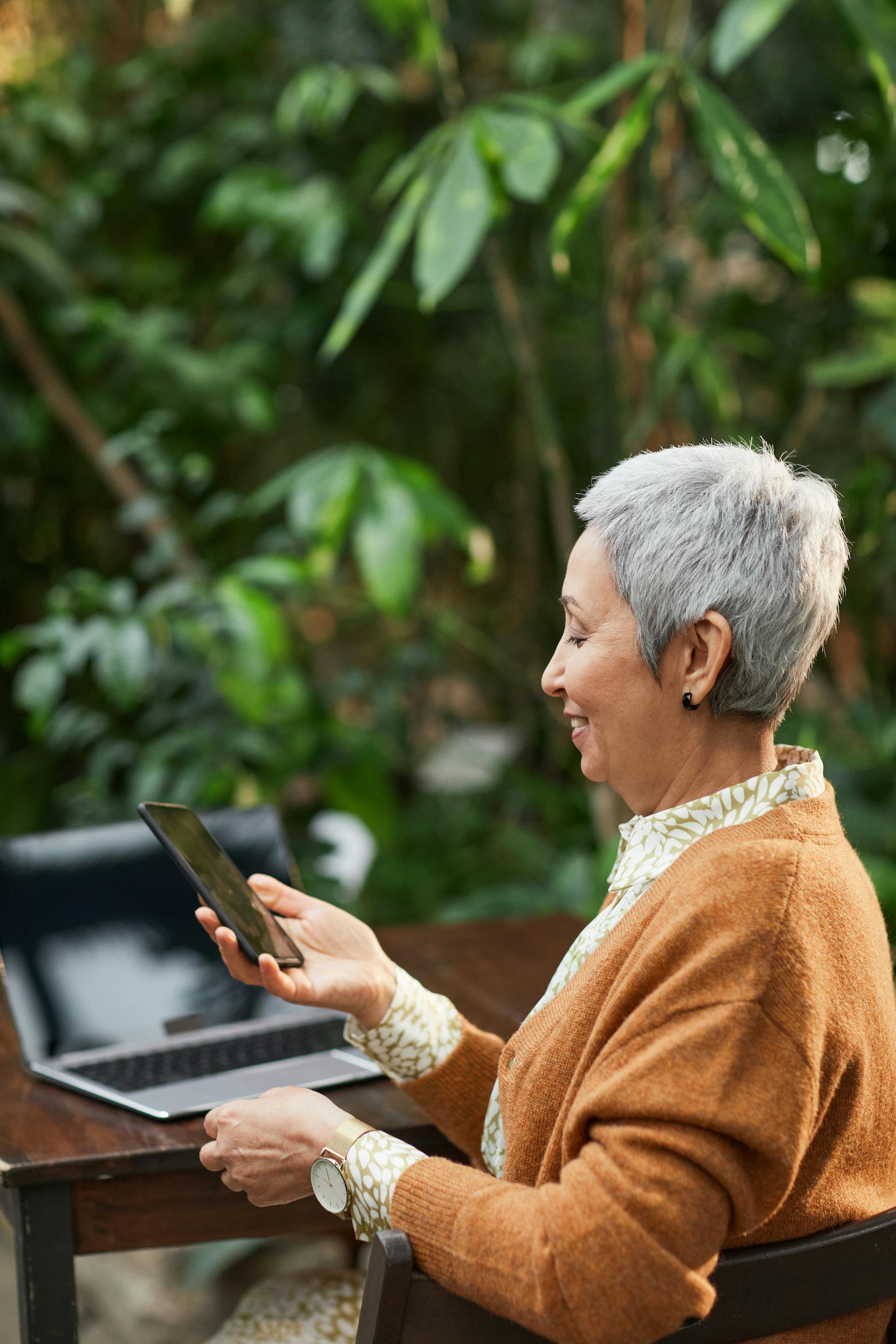 Une femme âgée sourit en regardant son téléphone | Source : Pexels