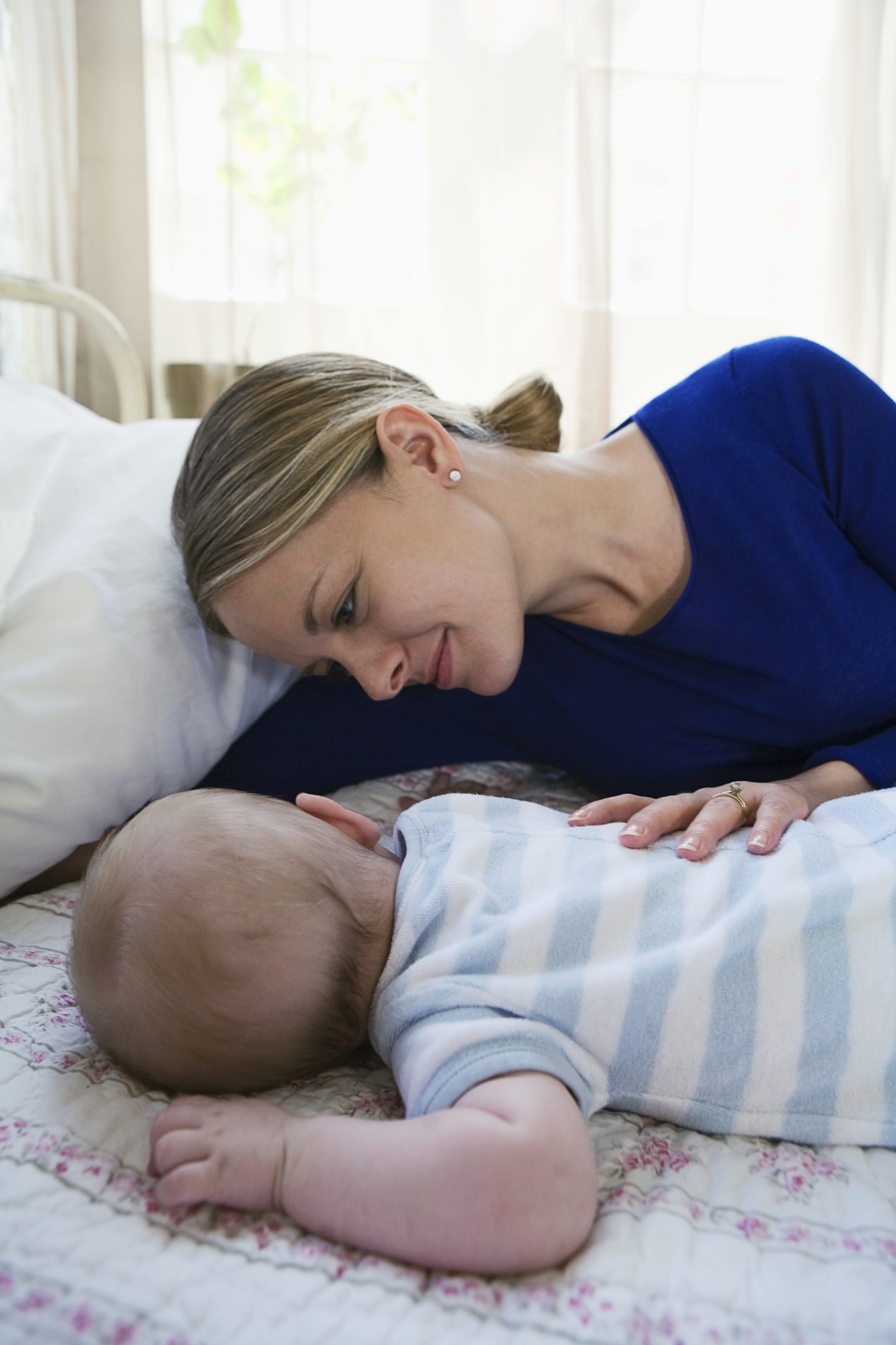 Een moeder waakt over haar slapende baby | Bron: Getty Images