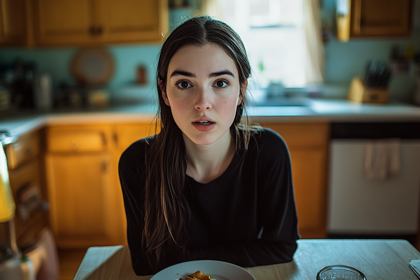 Une femme choquée assise à une table de dîner | Source : Midjourney