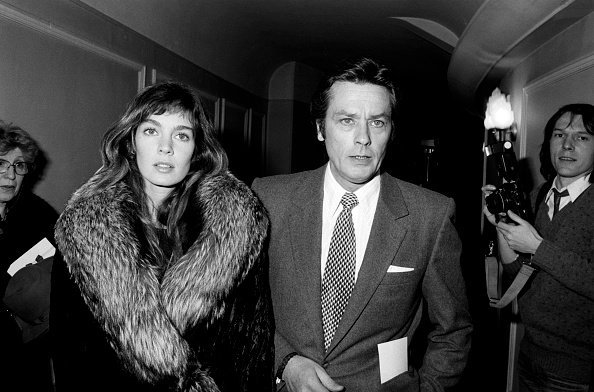 Alain Delon et Anne Parillaud à la 1ère du spectacle de Thierry Le Luron à Paris en 1982, France. | Photo : Getty Images