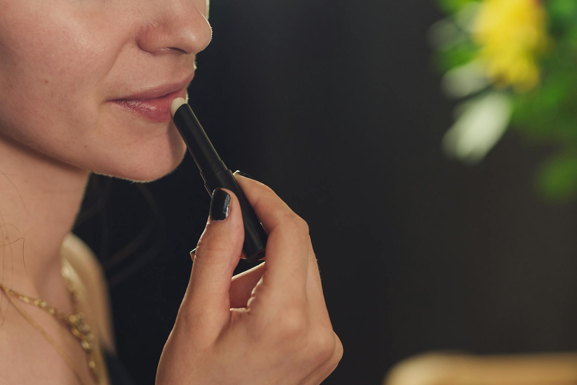 Gros plan d'une femme appliquant du rouge à lèvres | Source : Pexels