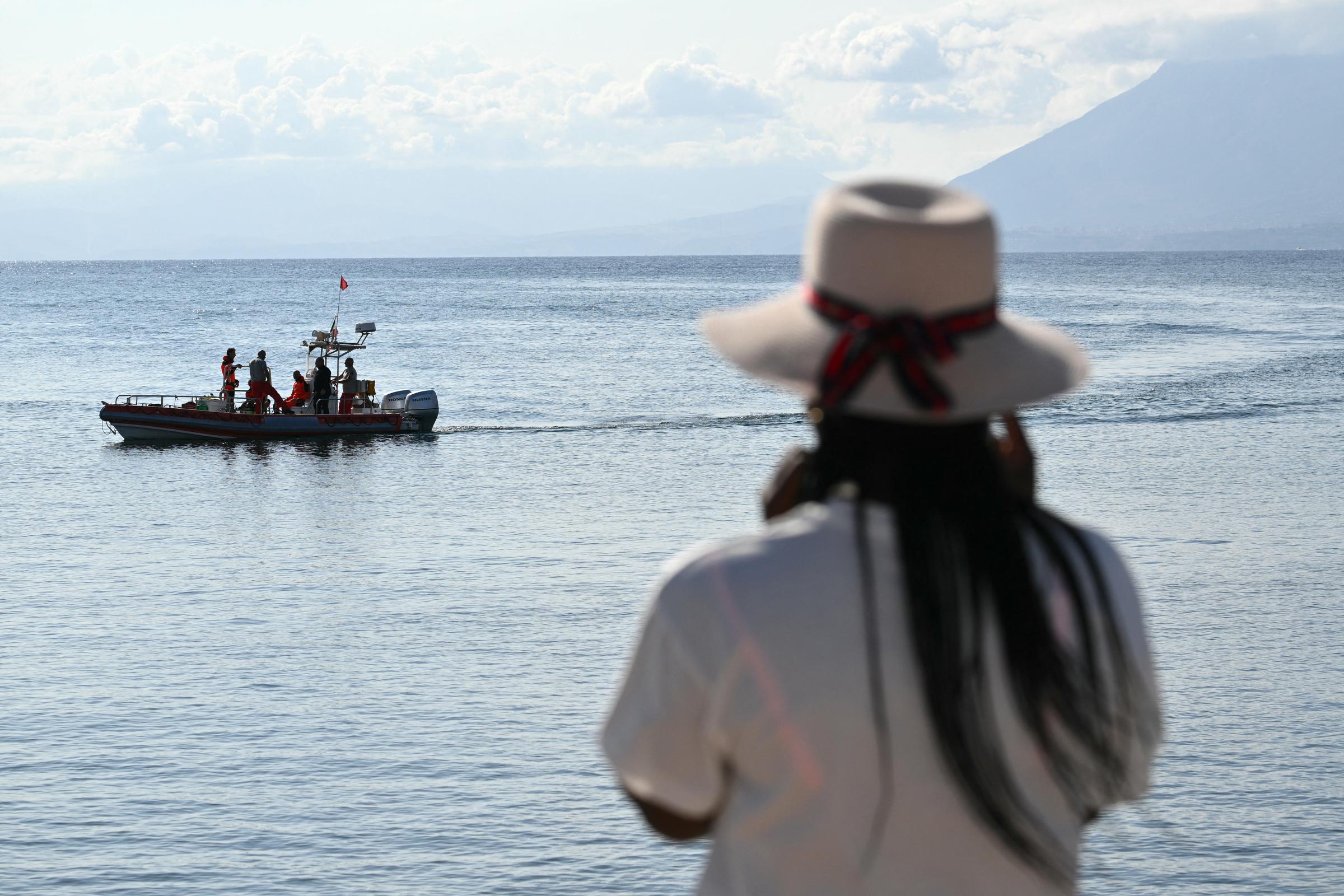 Une femme observe les équipes de secours au travail à Porticello, en Italie, le 21 août 2024, deux jours après le naufrage du yacht de luxe Bayesian, battant pavillon britannique. | Source : Getty Images