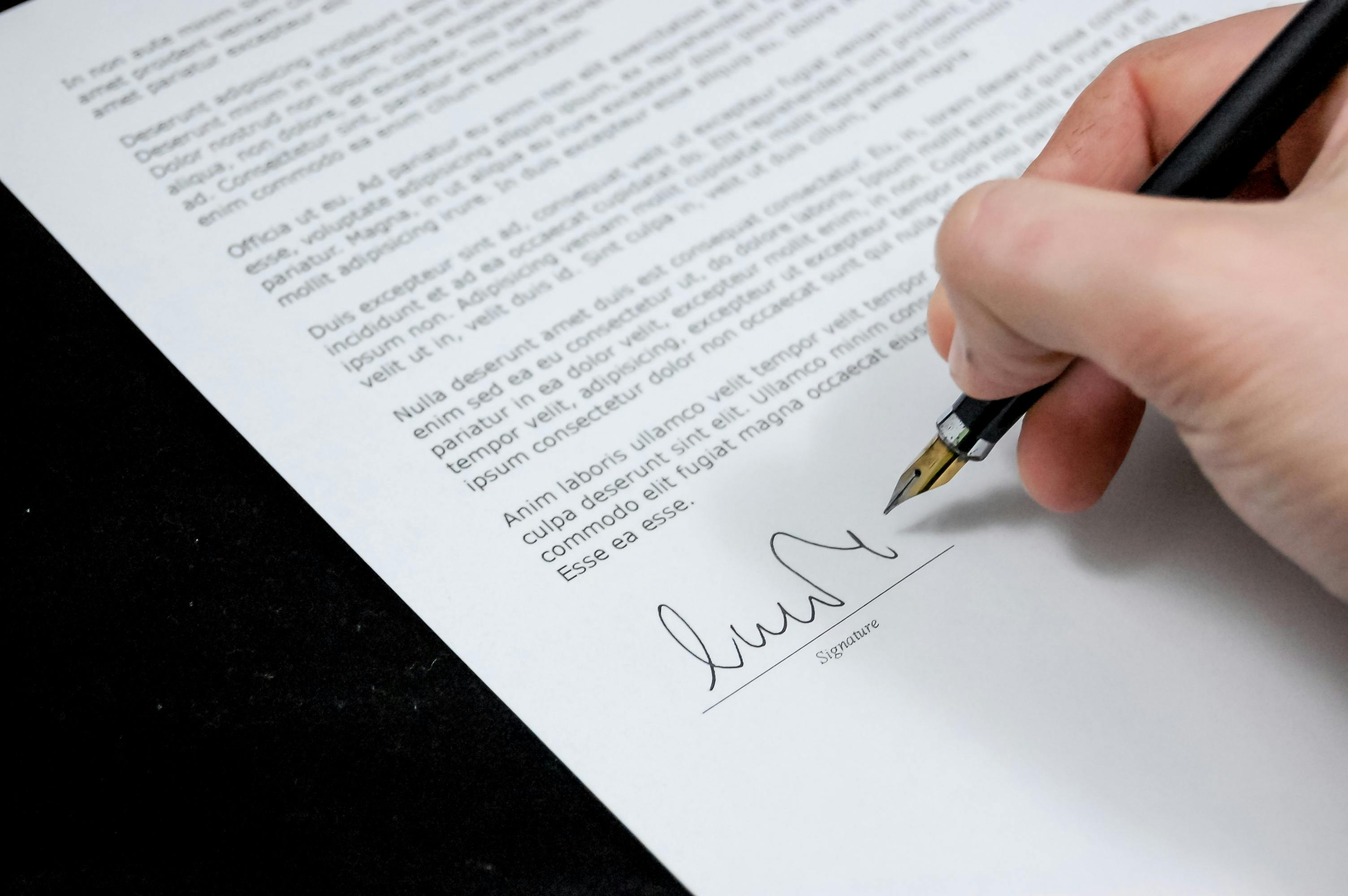 Une personne signant un document | Source : Pexels