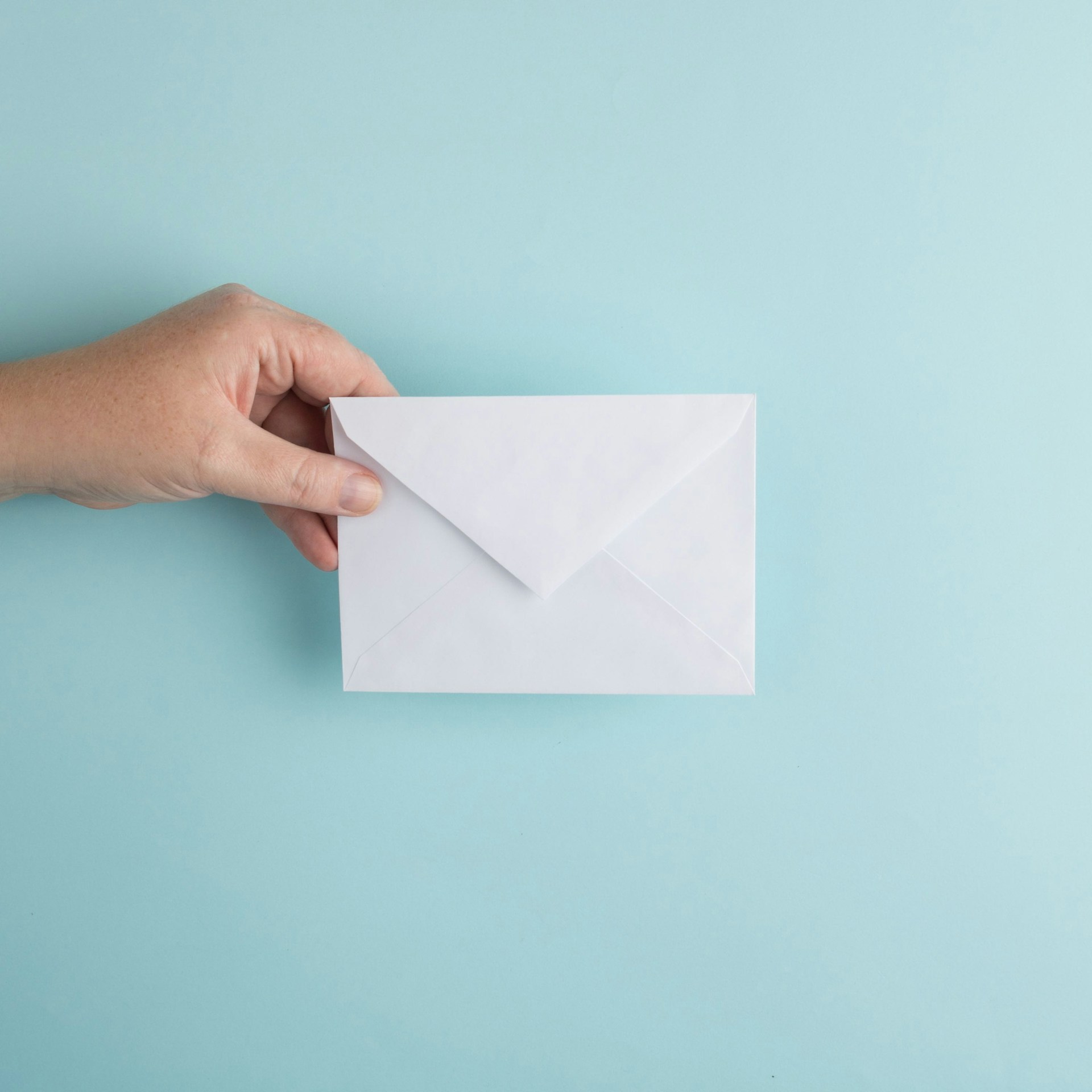 La main d'un homme tenant une enveloppe | Source : Unsplash