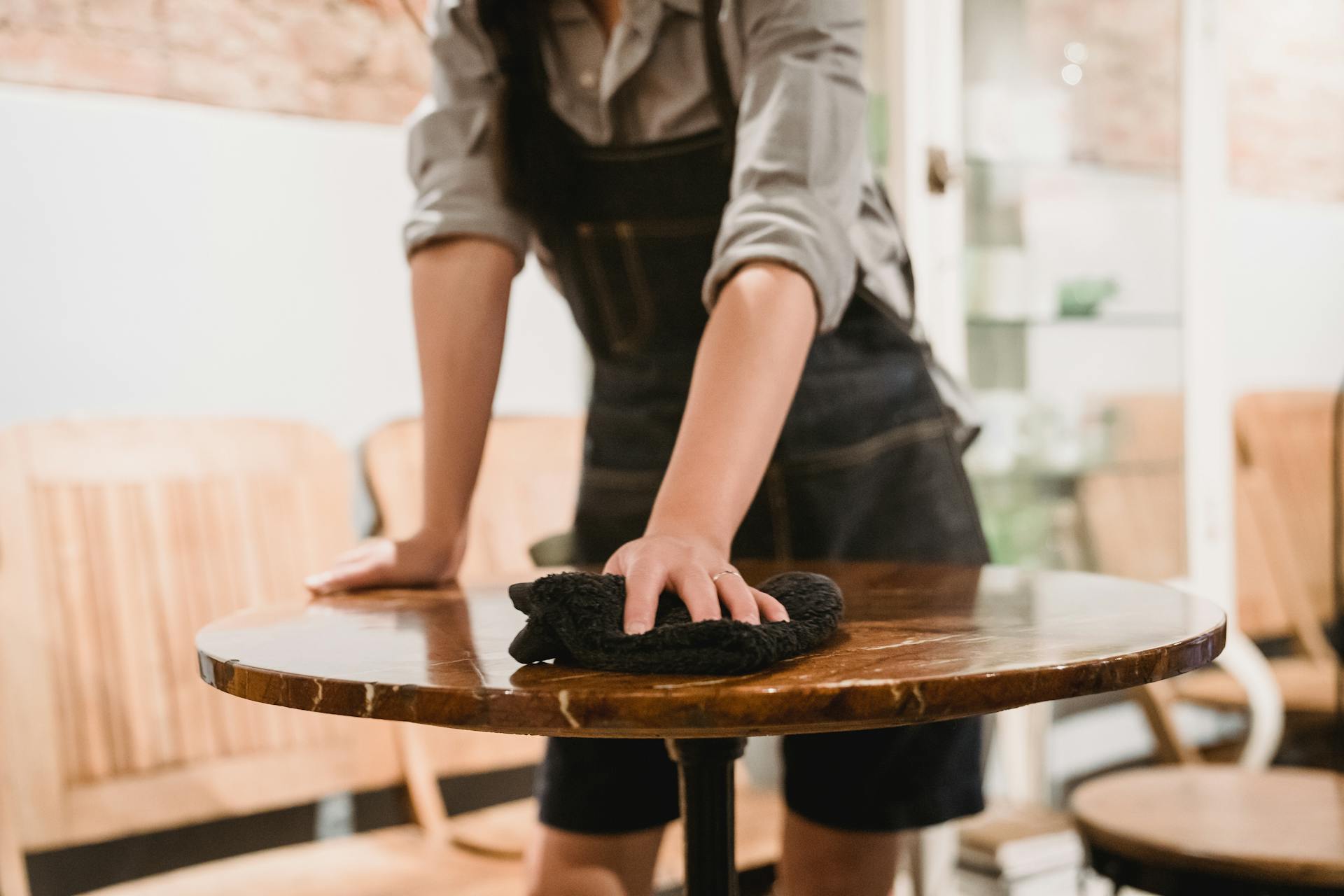Un homme essuie une table dans un restaurant | Source : Pexels
