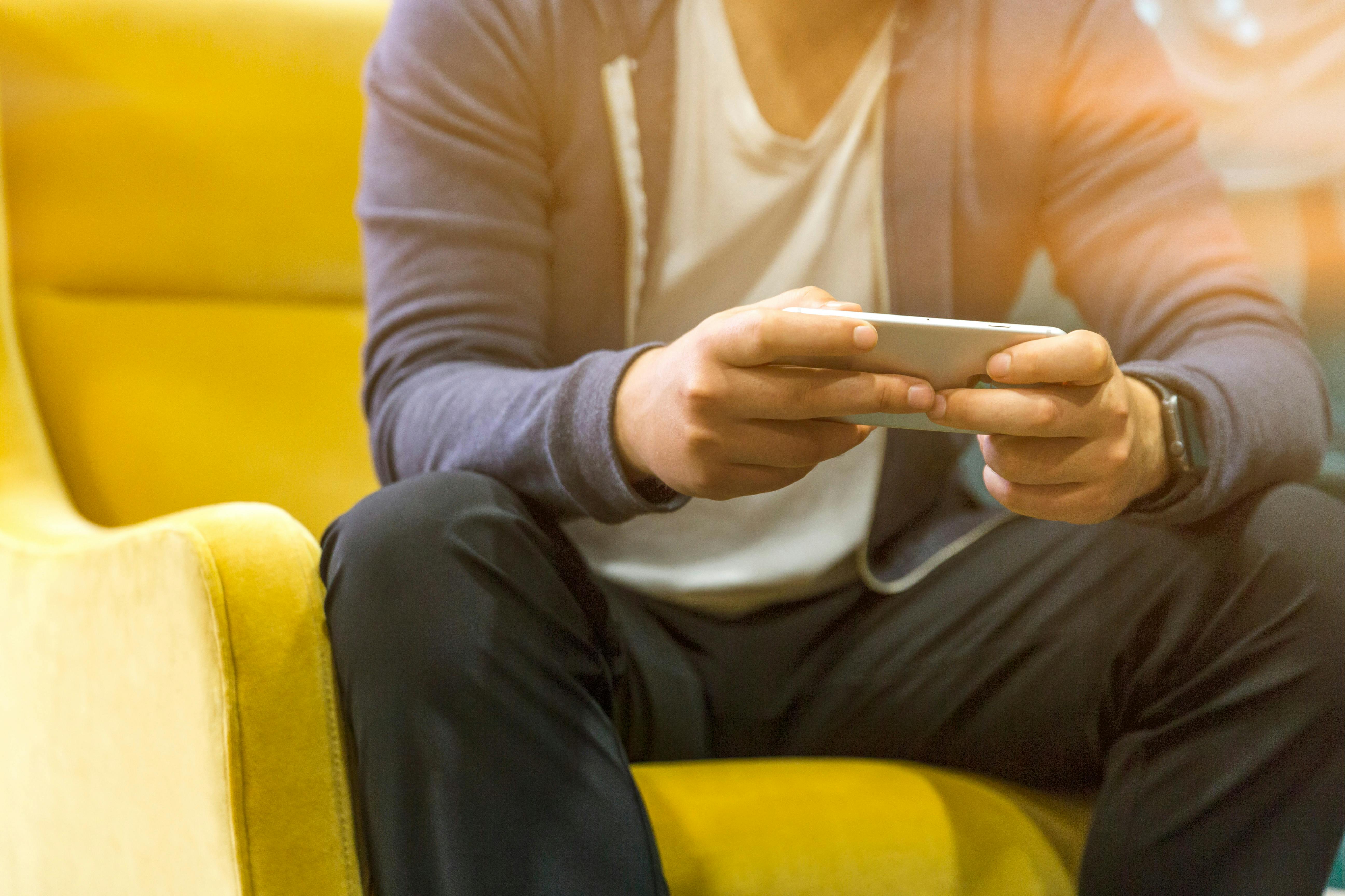 Un homme qui joue sur son téléphone | Source : Pexels