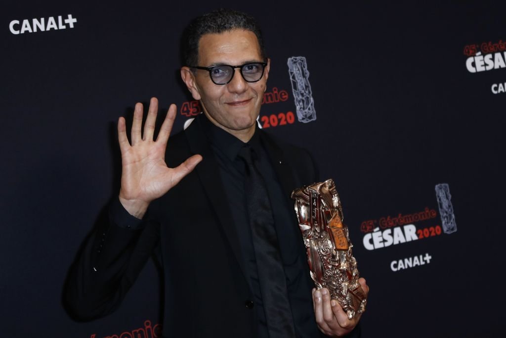 Roschdy Zem pose avec son trophée lors d'un photocall après avoir remporté le prix du meilleur acteur pour "Roubaix le 28 février 2020. | Photo : Getty Images