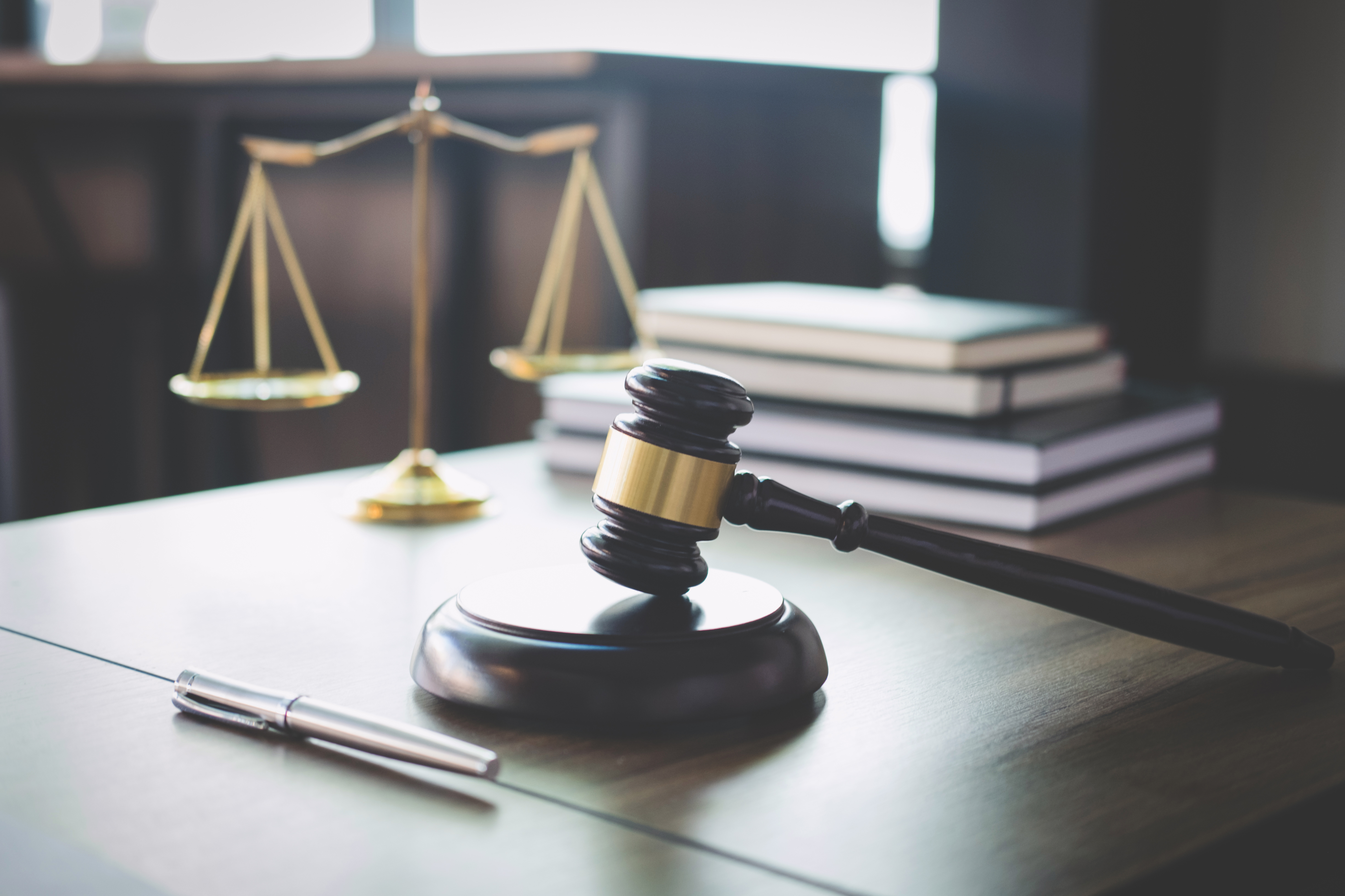 La balance de la justice et le marteau posés sur une table en bois dans le bureau d'un avocat | Source : Getty Images