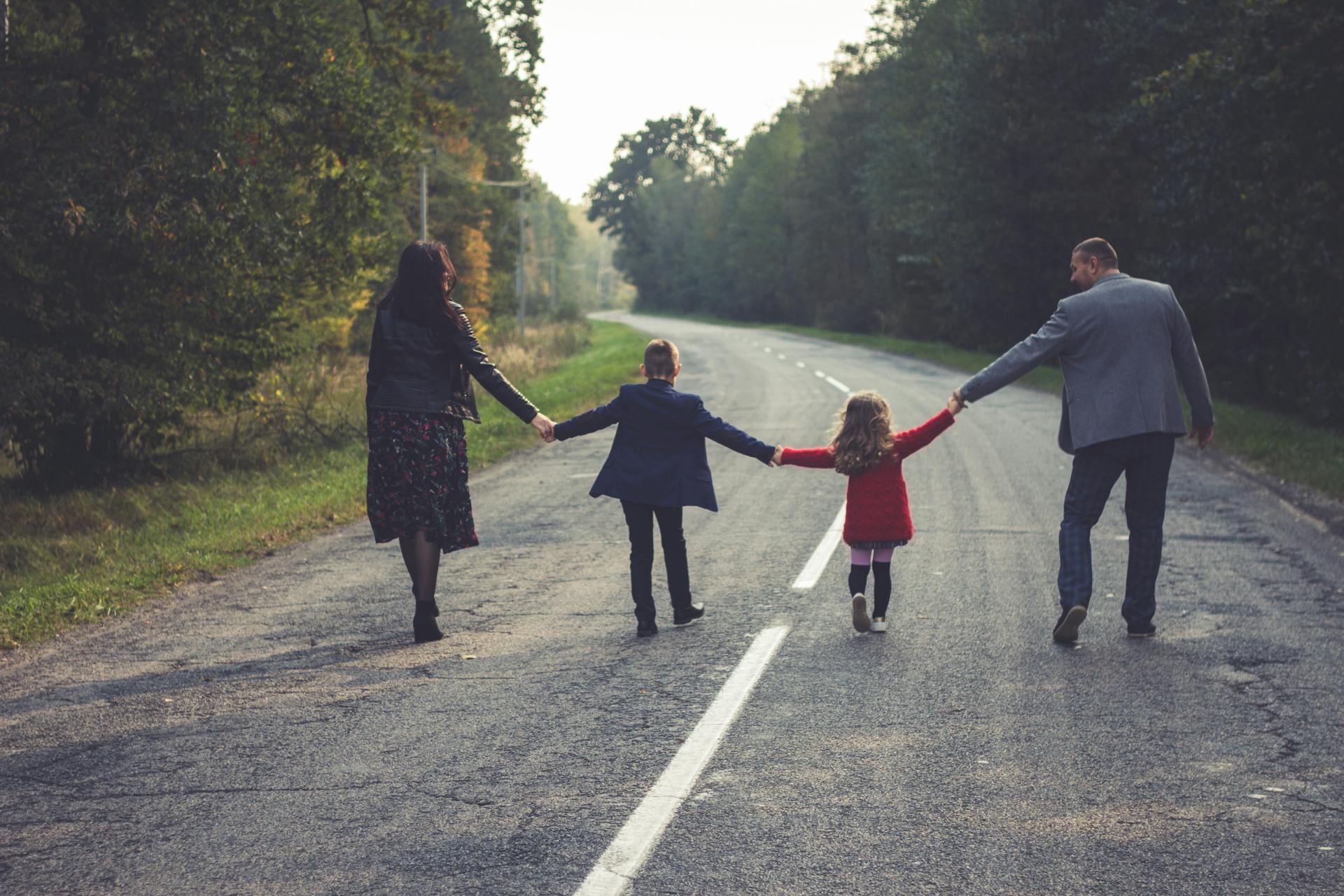 Une famille de quatre personnes marchant sur une route | Source : Pexels