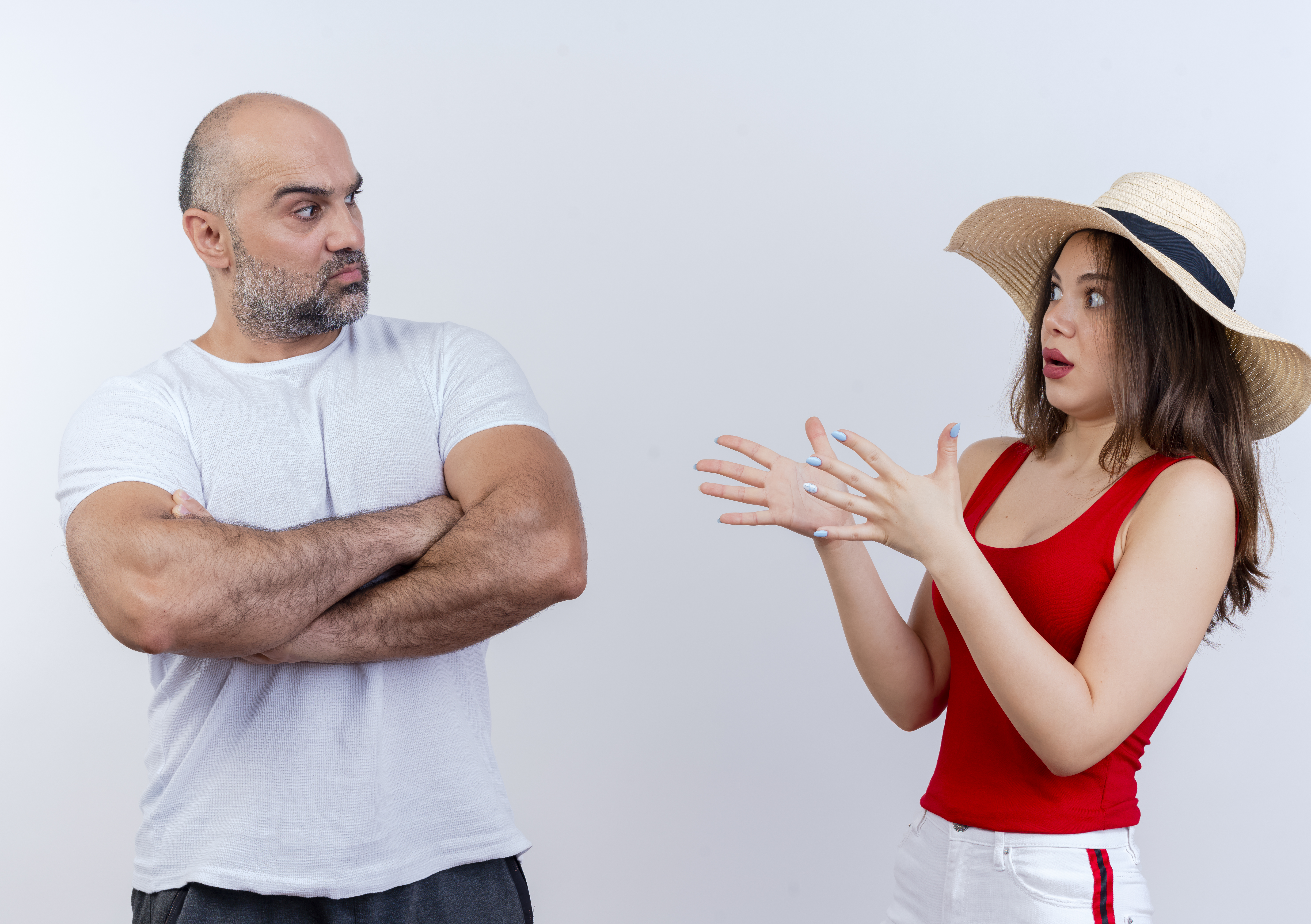 Homme montrant sa désapprobation à une femme portant un haut et un chapeau rouges | Source : stockking on Freepik