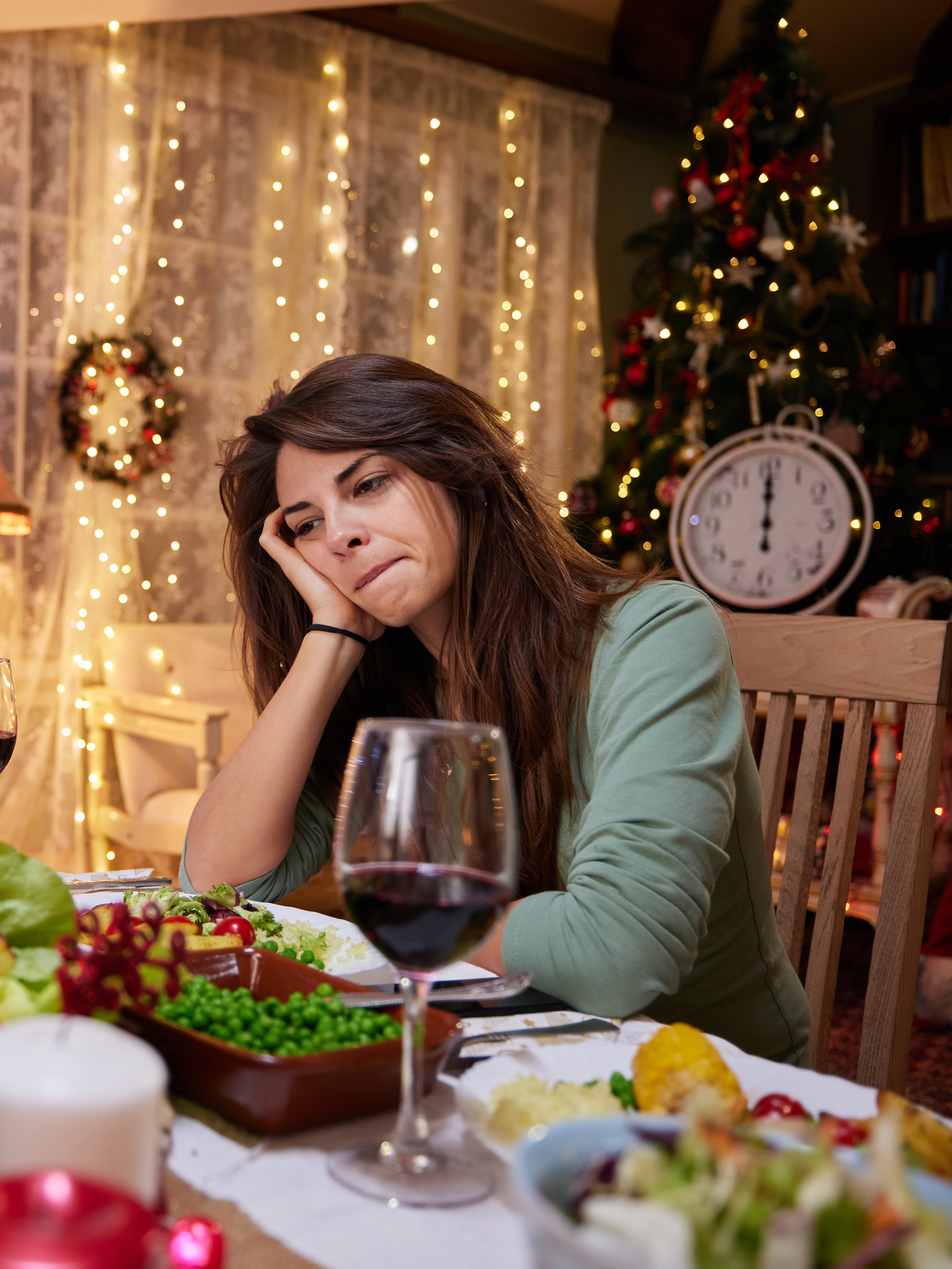 Une femme triste assise seule à une table à manger la veille de Noël | Source : Getty Images