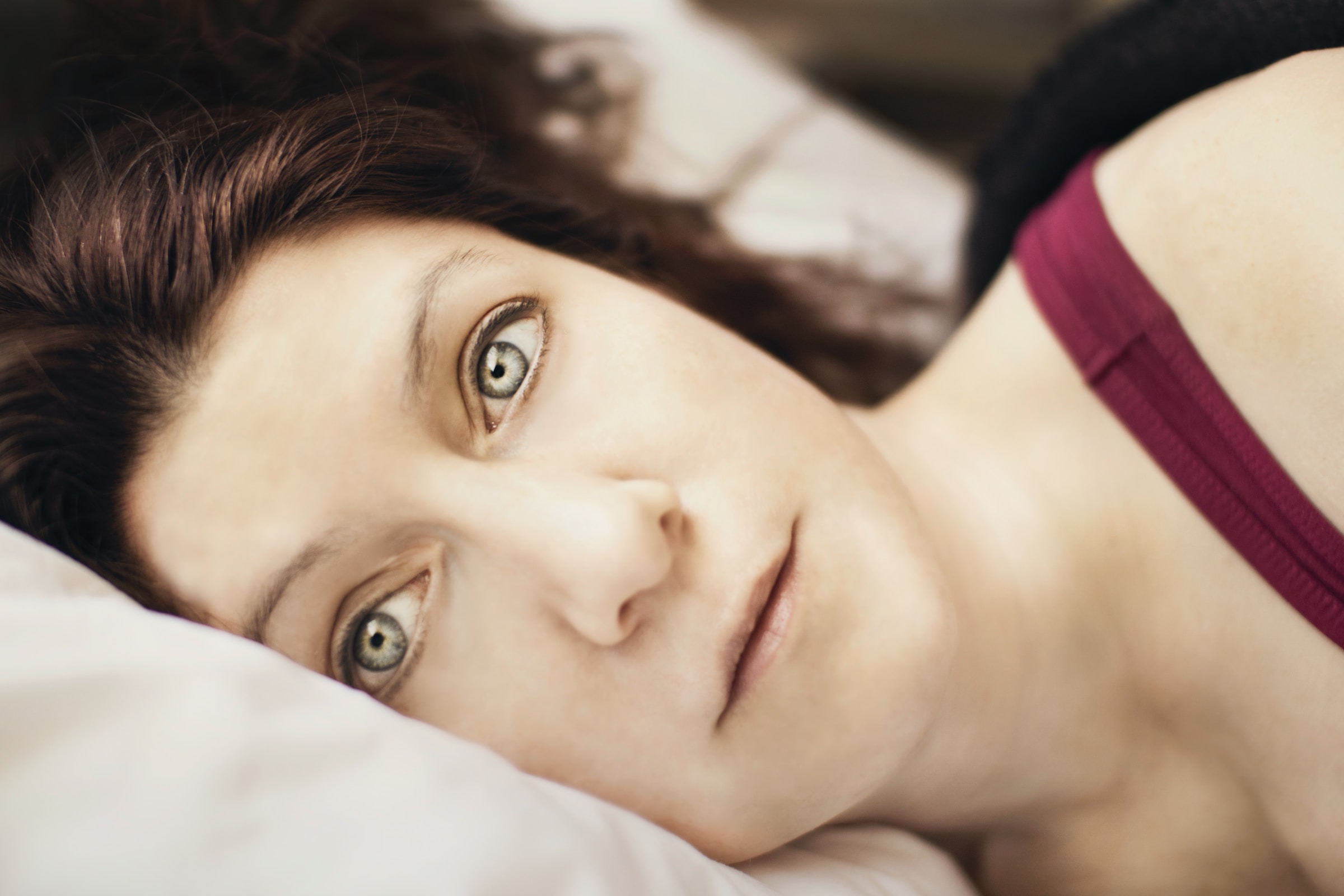 Une femme allongée dans son lit n'arrivant pas à trouver le sommeil | Source : Unsplash