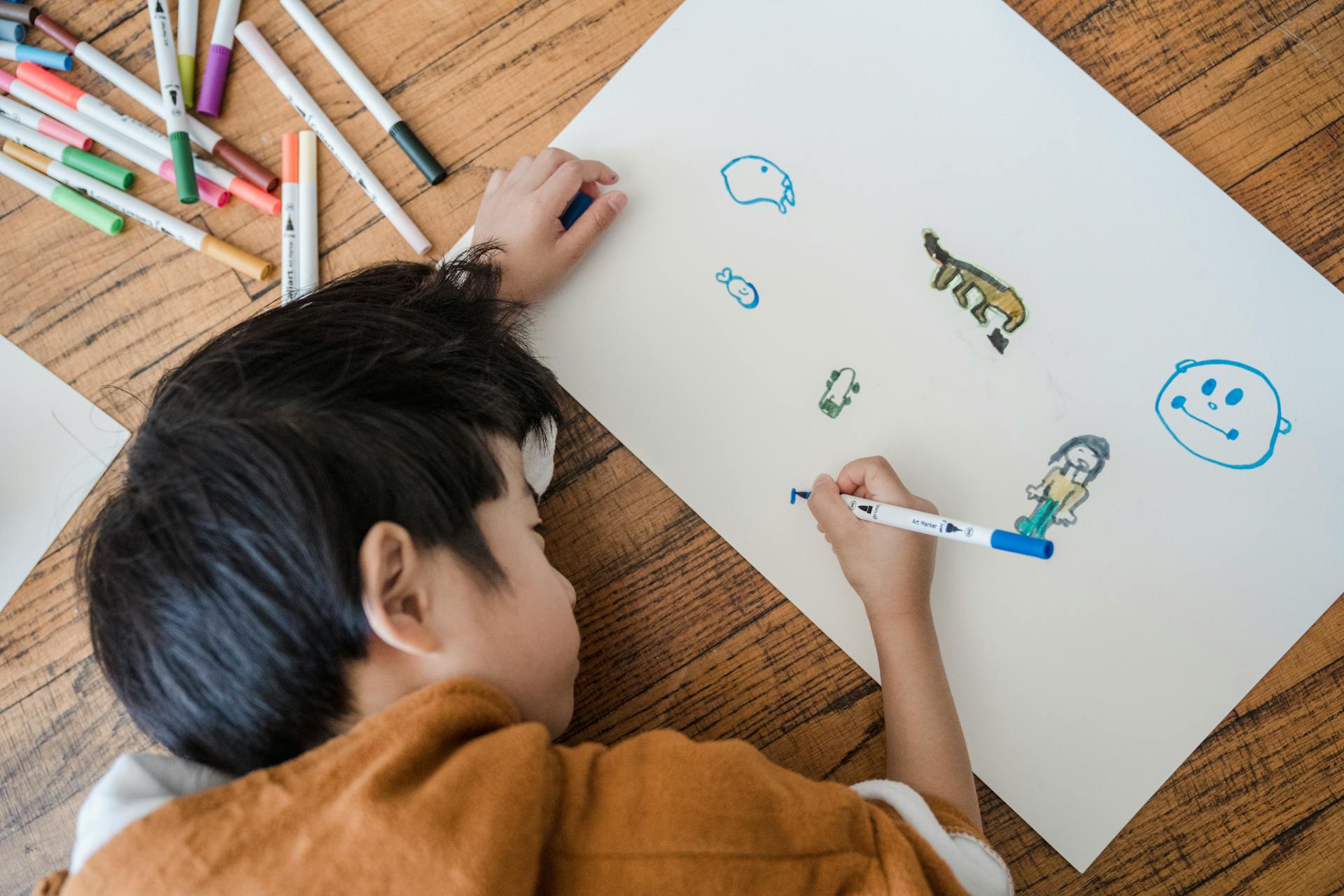 Un garçon qui dessine sur un papier | Source : Pexels