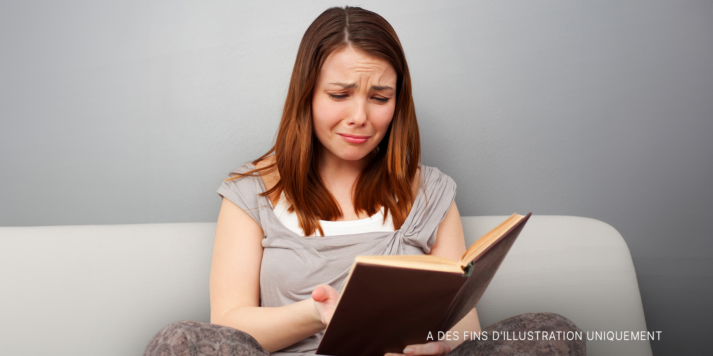 Une femme lisant un livre et pleurant | Source : Shutterstock