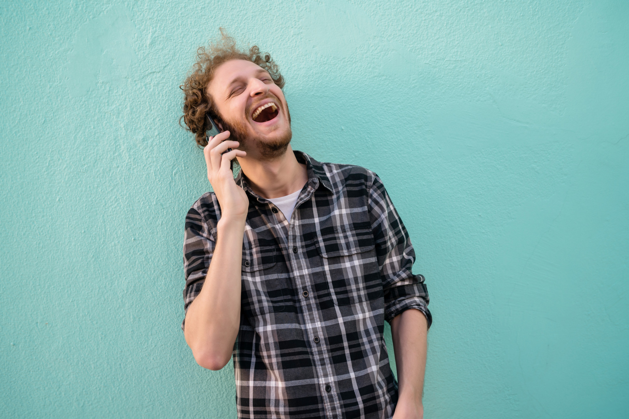 Un homme rit tout en parlant à son téléphone | Source : Freepik