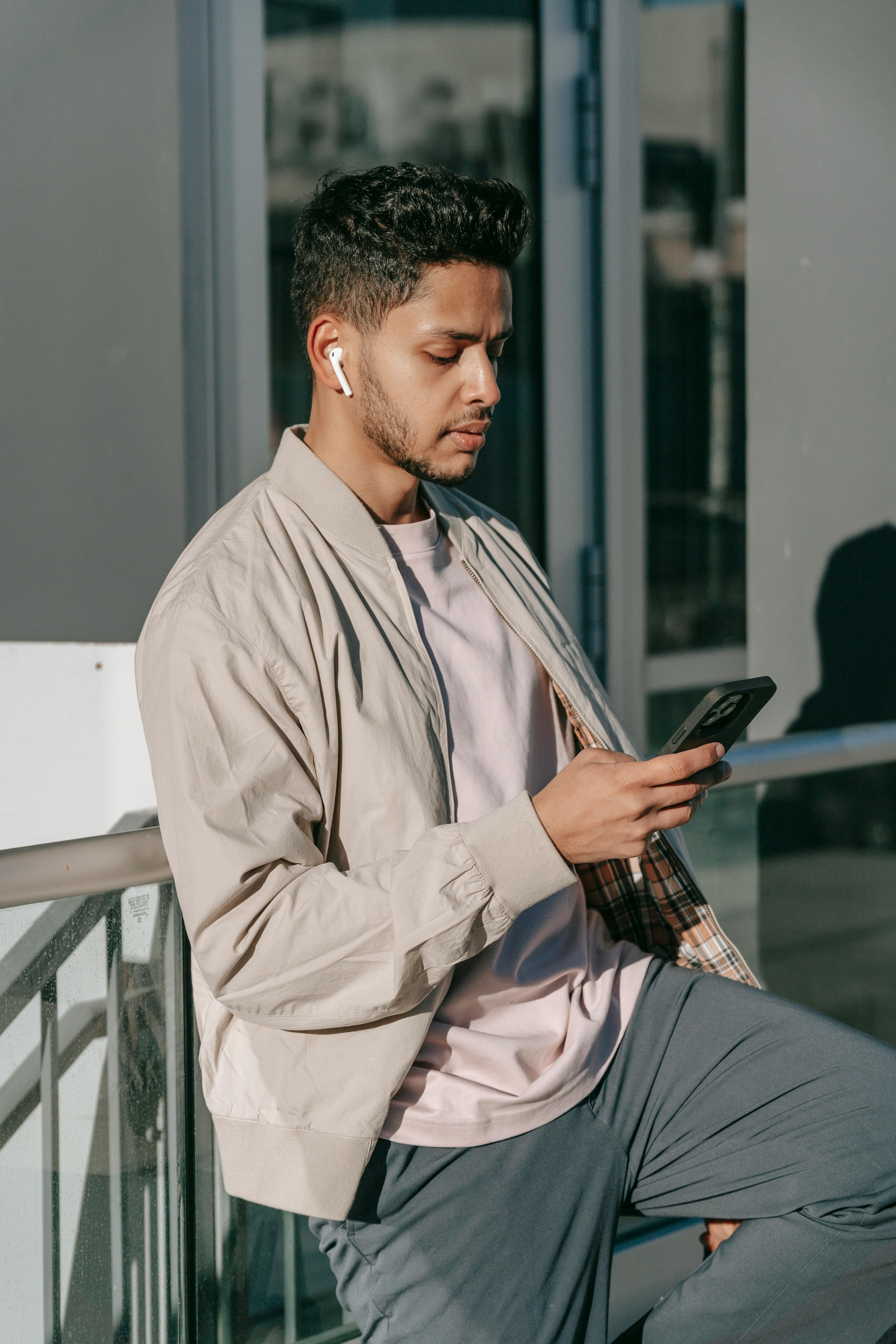 Un jeune homme parlant sur son téléphone en utilisant des oreillettes | Source : Pexels